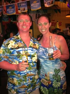 two people standing next to each other holding beer bottles