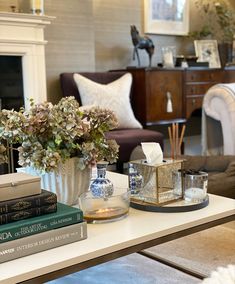 a living room filled with furniture and a white coffee table topped with vases full of flowers