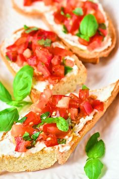 two pieces of bread with tomatoes and basil on top