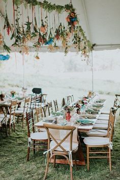 an outdoor tent with tables and chairs set up for a dinner party under the canopy