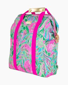 a pink and green floral print bag with straps on the front, sitting against a white background