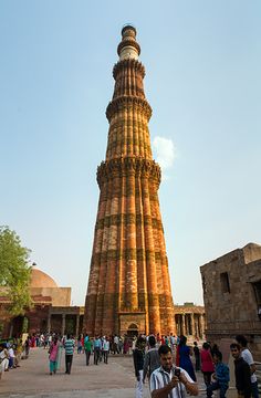 people walking around in front of a tall tower