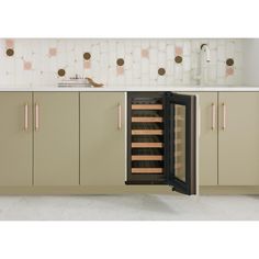 an open wine cooler in the middle of a kitchen with beige cabinets and white countertops