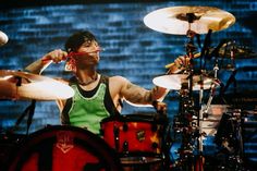 a man playing drums on stage with other drummer's equipment in front of him