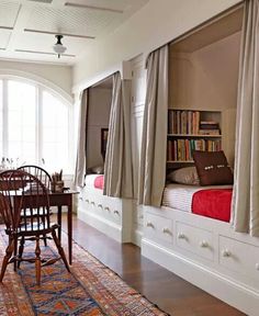 a dining room table and chairs in front of a bed with built - in bookshelves