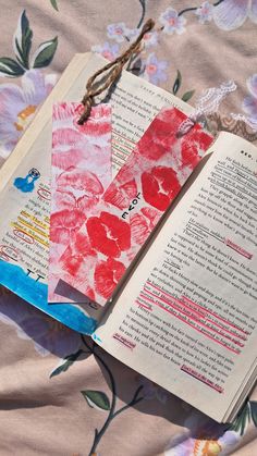 an open book with paper flowers on it next to a piece of string and twine