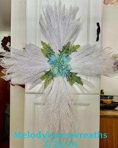 a white and blue flower hanging from the side of a door in front of a kitchen