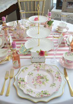 a table set with plates, cups and utensils for a fancy dinner party