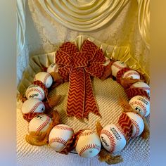 a wreath made out of baseballs and burlocks with a bow on top