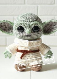 a crocheted baby yoda doll sitting on top of a table