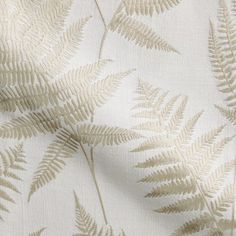 a close up view of a white fabric with green leaves on the front and back