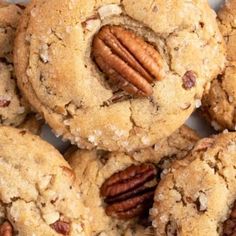 a pile of cookies with pecans on top