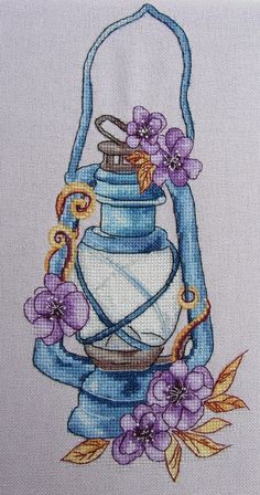 a blue lantern with purple flowers on it