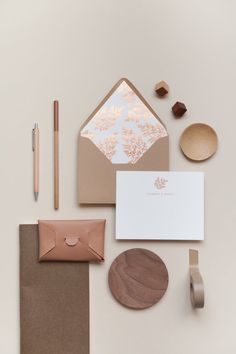 the stationery is laid out neatly on top of each other, including a notepad, envelope and pen