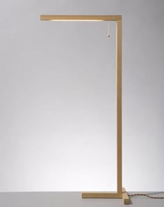 a light that is on top of a white surface with a long wooden pole in front of it