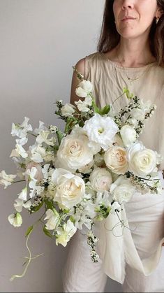 a woman holding a bouquet of white flowers