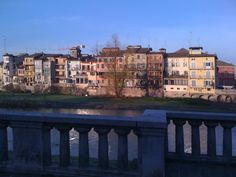 some buildings are next to a body of water with a bridge in the foreground