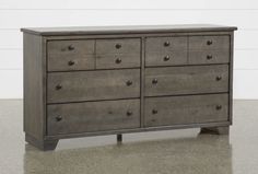 an old dresser with many drawers and knobs on the bottom drawer, against a white wall