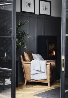 a chair with a blanket on it next to a fire place