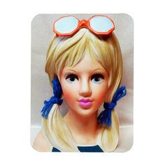 a barbie doll with sunglasses on it's head and blonde hair wearing blue bows