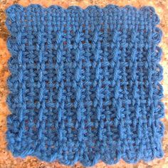 a blue crocheted dishcloth sitting on top of a counter