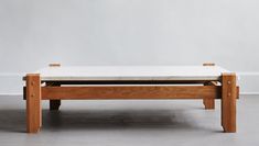 a wooden bench with a white cushion on it