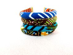 Ce bracelet manchette fabriqué à partir de quatre tubes cousus bourré et monté par mes soins. J’ai utilisé imprimé wax africain. La longueur est cm21 long et cm 3 de large. Les couleurs sont superbes, qui correspondent à quelque chose de blanc à des tenues sombres et très léger en poids. African Bangles, Large Cuff Bracelet, Fabric Cuff Bracelet, African Bracelets, Style Africain, Multicolor Jewelry, African Earrings, Wedding Bridesmaid Jewelry, Fabric Earrings