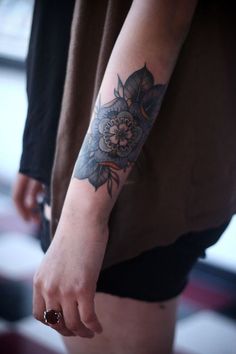 a woman's arm with a flower tattoo on the left side of her body