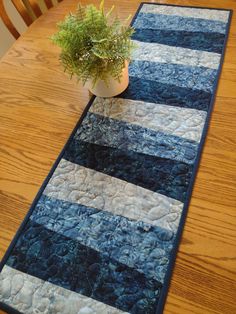 a potted plant sitting on top of a wooden table next to a blue rug