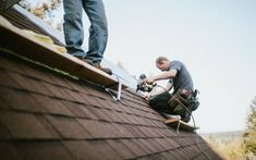 a man working on the roof of a house