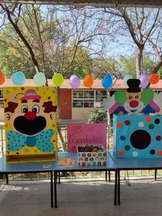 three tables with clowns on them in front of a building