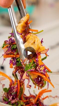 someone is cutting up some food in a bowl with chopsticks on the side