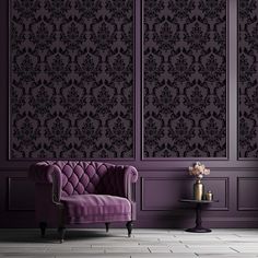 a purple couch sitting in front of a wall with black damask on it's walls