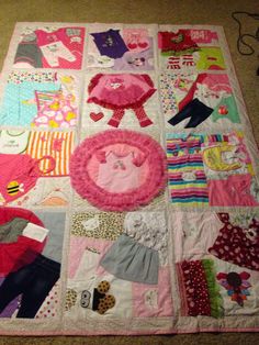 a child's quilted blanket with various clothes and accessories laid out on the floor