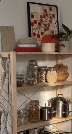 the shelves in this kitchen are filled with various foods and cooking utensils on them