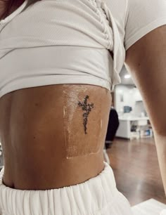 a woman with a cross tattoo on her stomach