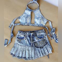 Elevate Your Style With Our Space Denim Set! This One-Of-A-Kind Set Features A Skirt And Top Made From Upcycled Space Denim, Adorned With Rhinestones, Chains, And Charms. Custom Handmade With Distressed Details And Silver Paint Accents. The Top Is Adjustable Xs - M Cup B And Skirt Is Xs (0-2) Stand Out From The Crowd And Make A Statement With This Unique And Fashionable Set! Festival Fitted Denim Bottoms, Fitted Denim Bottoms For Festival, Spring Festival Fitted Jean Shorts, Fitted Jean Shorts For Spring Festival, Fitted Medium Wash Bottoms For Festival, Fitted Y2k Denim Jean Shorts, Y2k Blue Jean Shorts For Spring, Fitted Recycled Denim Bottoms For Summer, Blue Y2k Jean Shorts For Spring