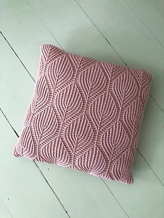 a pink pillow sitting on top of a wooden floor