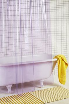 a bath tub sitting next to a yellow towel on top of a white countertop