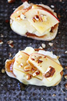 two pieces of bread with apples and nuts on them