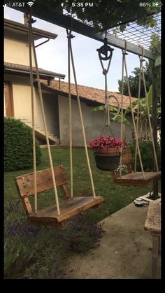 two wooden swings with flowers in the background