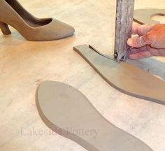 a pair of shoes is being made by someone using scissors to cut the soles