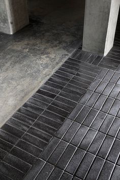 a black tile floor next to a concrete wall