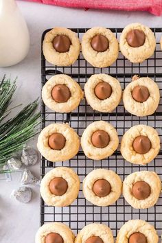 chocolate chip cookies on a cooling rack with christmas greenery and candles in the background