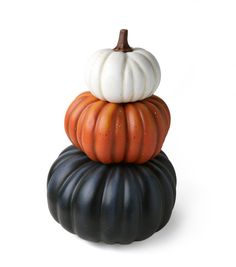 three pumpkins stacked on top of each other in black, white and orange colors