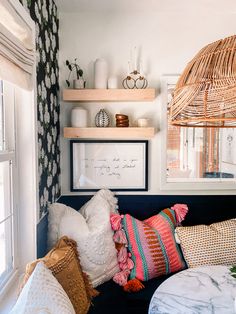 a living room filled with lots of furniture and decor on top of a wooden shelf