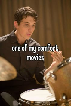 a man sitting in front of a drum set with the words one of my comfort movies