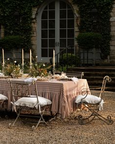 the table is set for four outside with candles