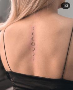 the back of a woman's shoulder with three phases on it