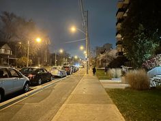 cars parked on the side of a street at night